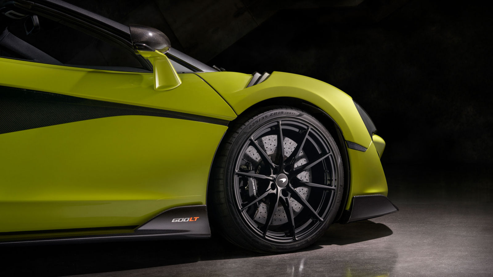 The front side of McLaren 600LT in vibrant green with carbon fiber aero, lightweight wheels, and high-performance braking system