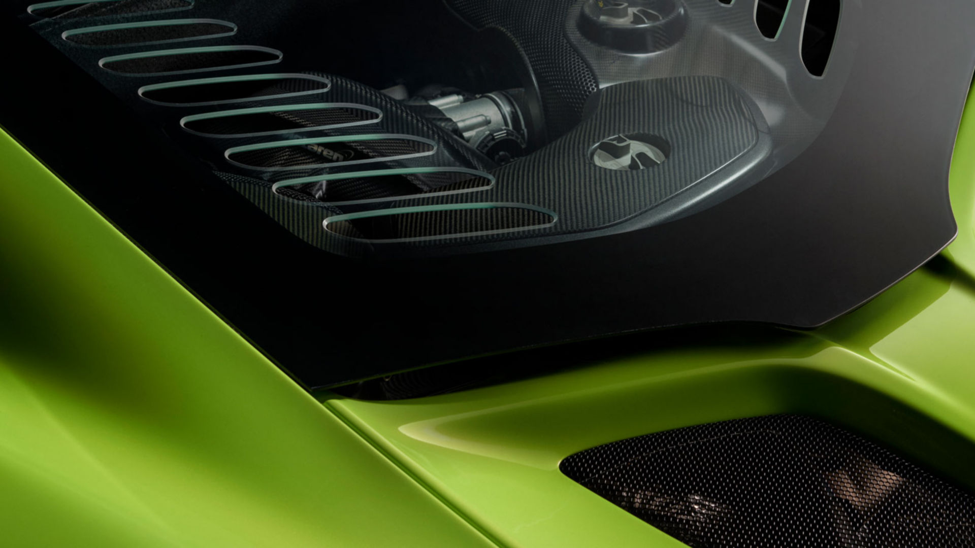 Close-up of a red McLaren supercar with dramatic lighting, showcasing aerodynamic curves and precision engineering