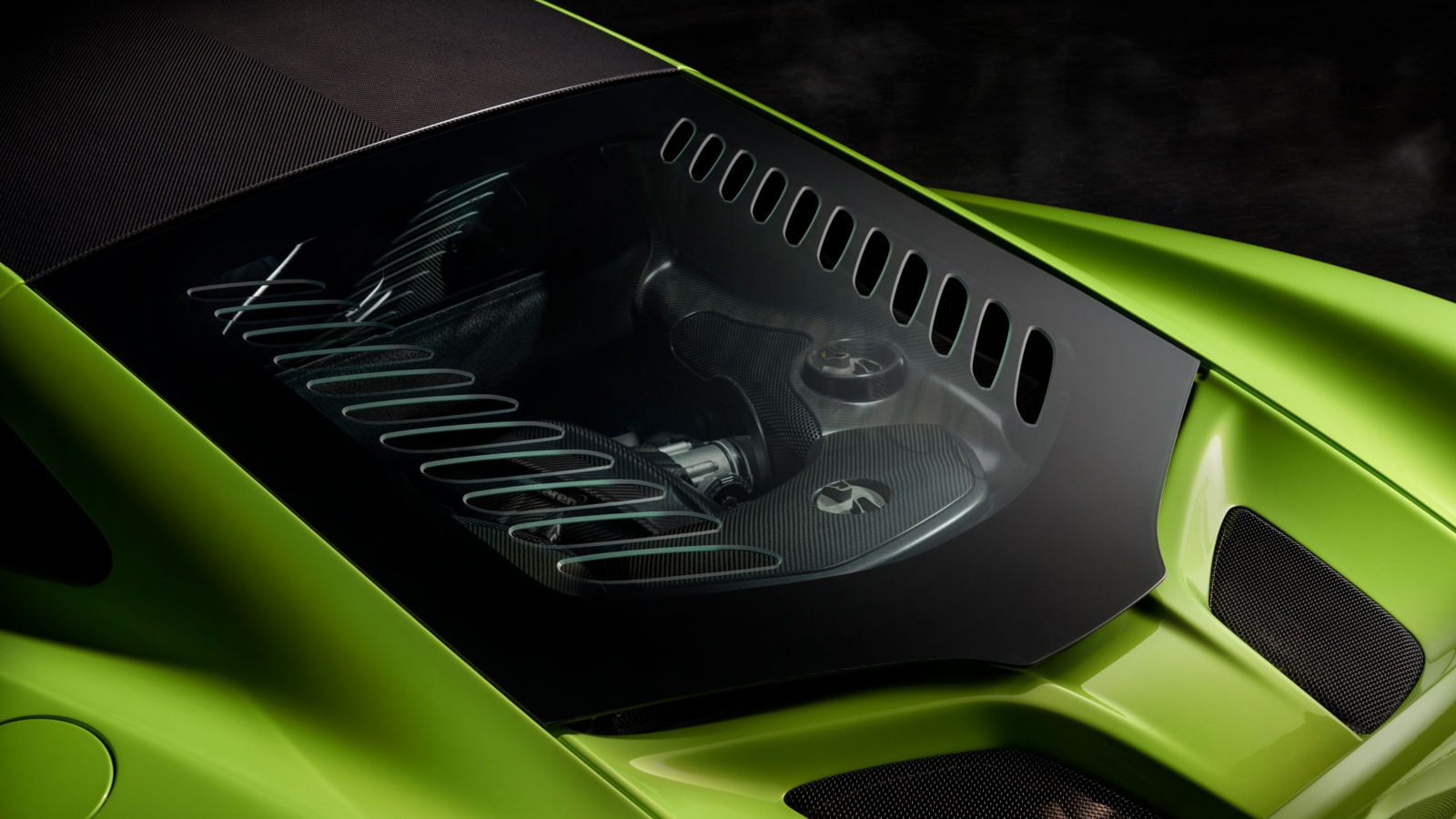 McLaren 675LT engine bay with carbon fiber detailing, visible through lightweight glass cover, showcasing engineering