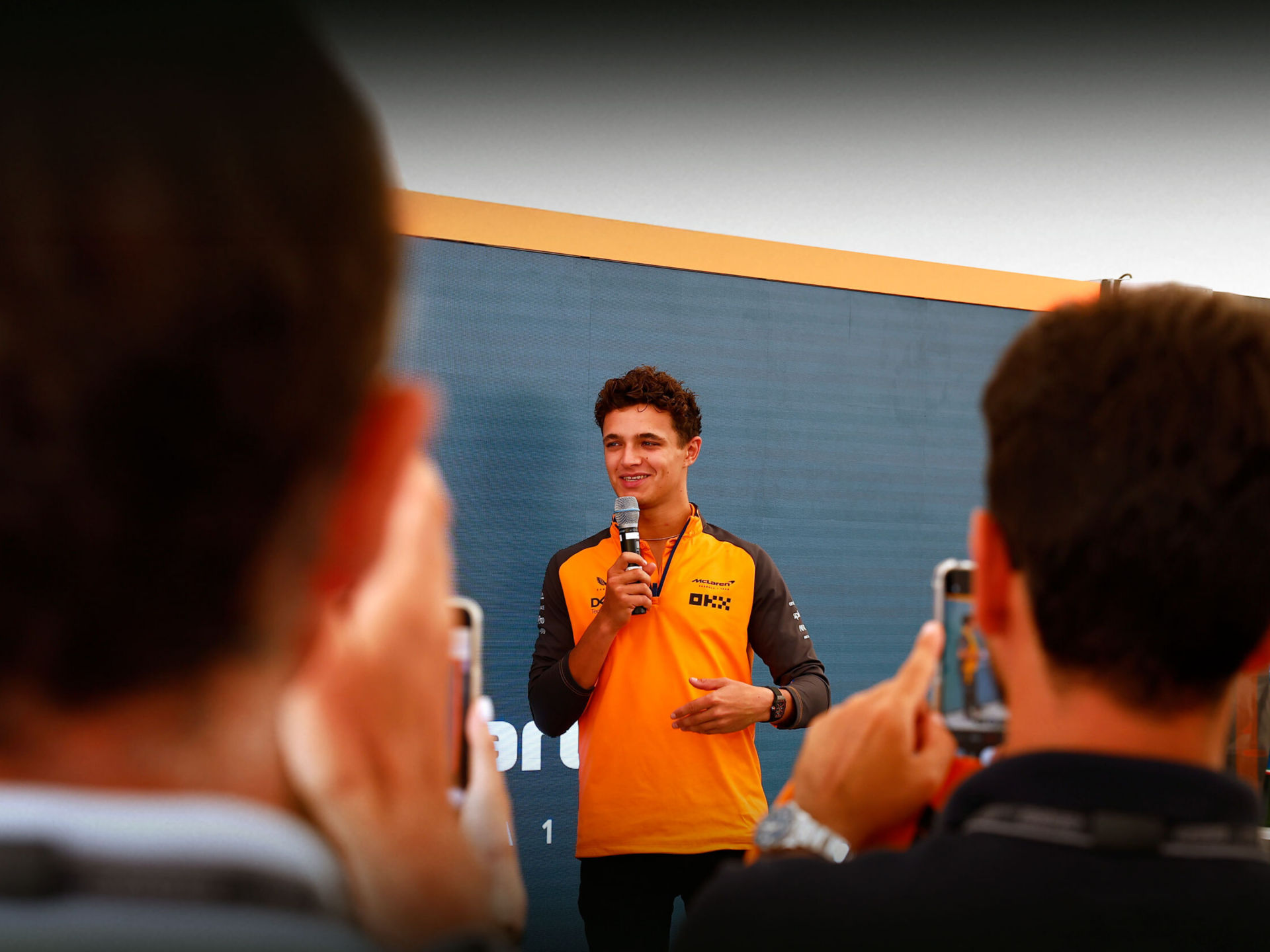 Lando Norris driving the McLaren W1 in his McLaren kit and helmet. 