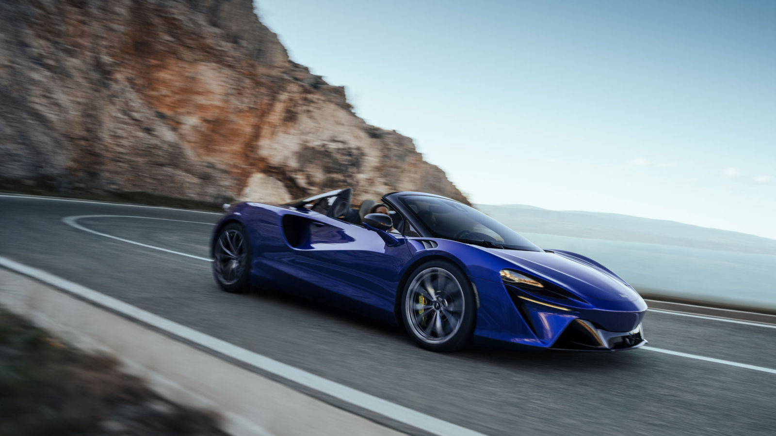 Shot of the McLaren Artura driving along a cliff top road.