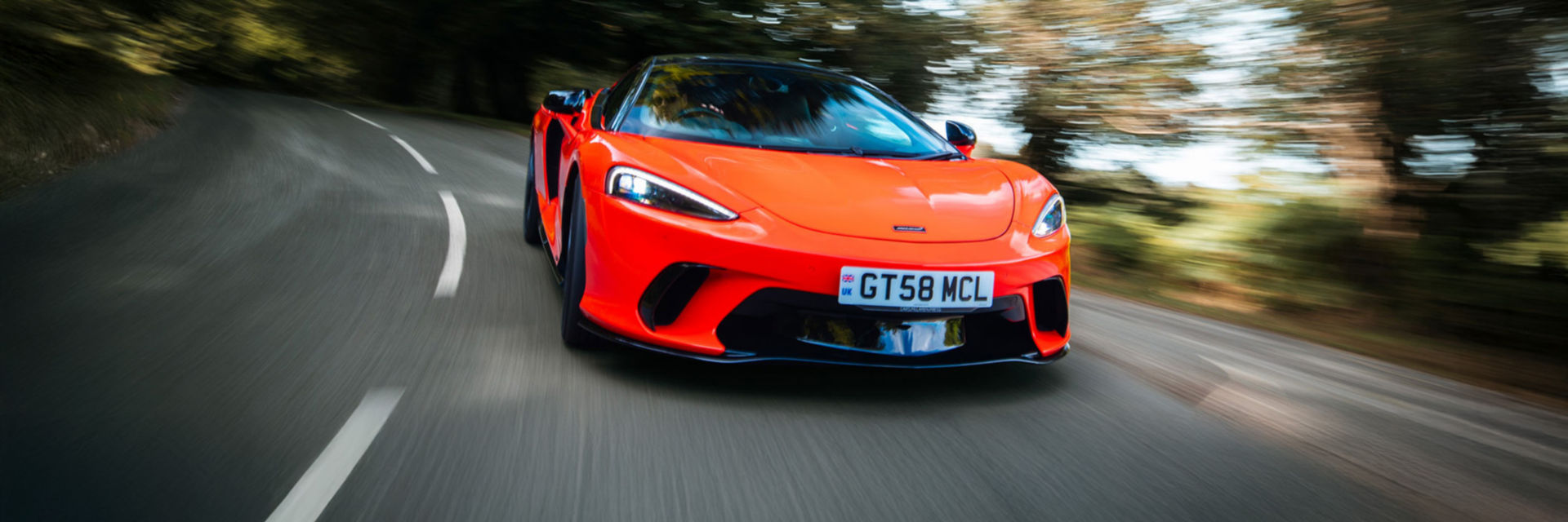 Landscape shot of the GTS driving at speed along a country road.