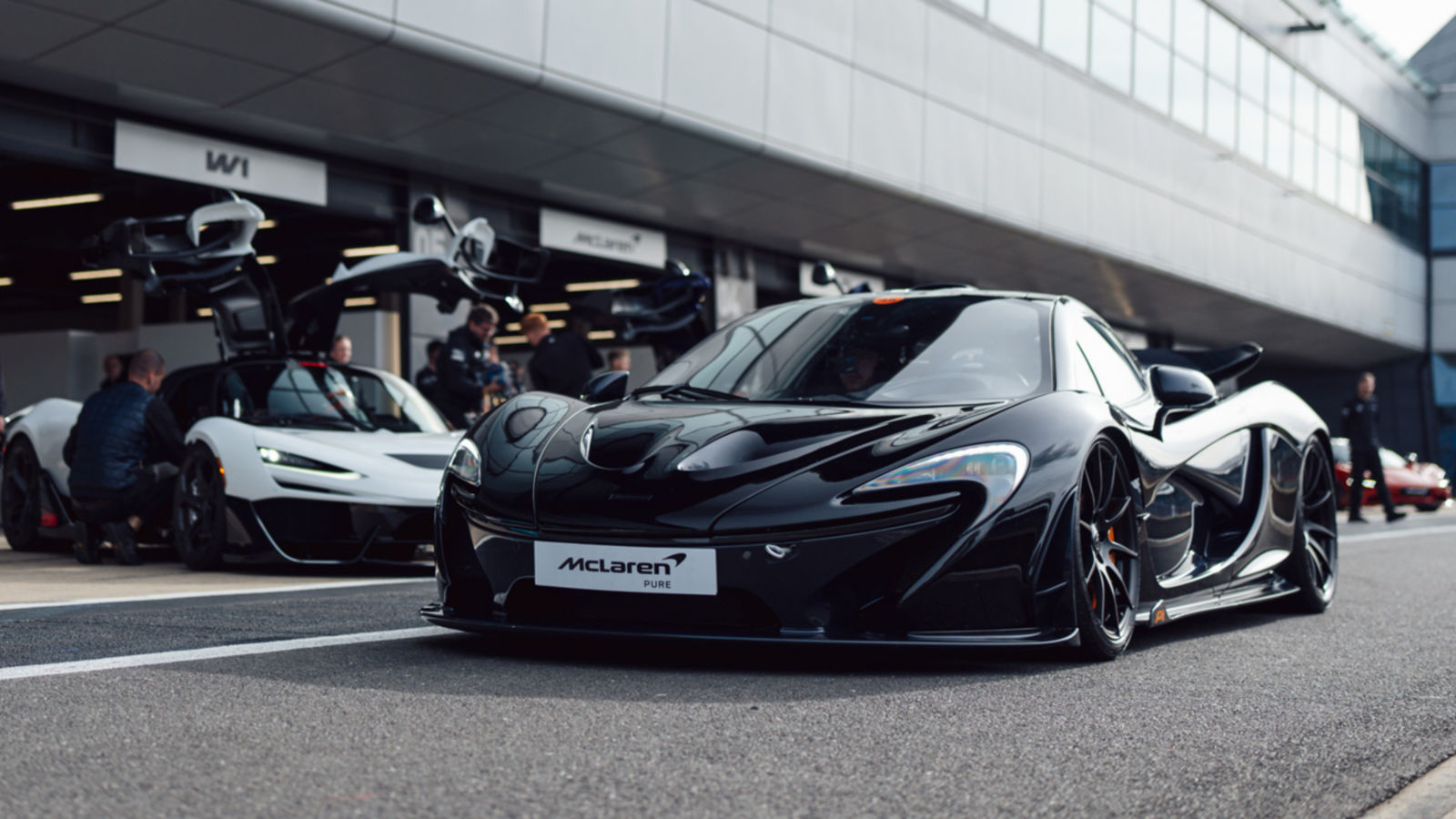McLaren team and guests standing on trackside.