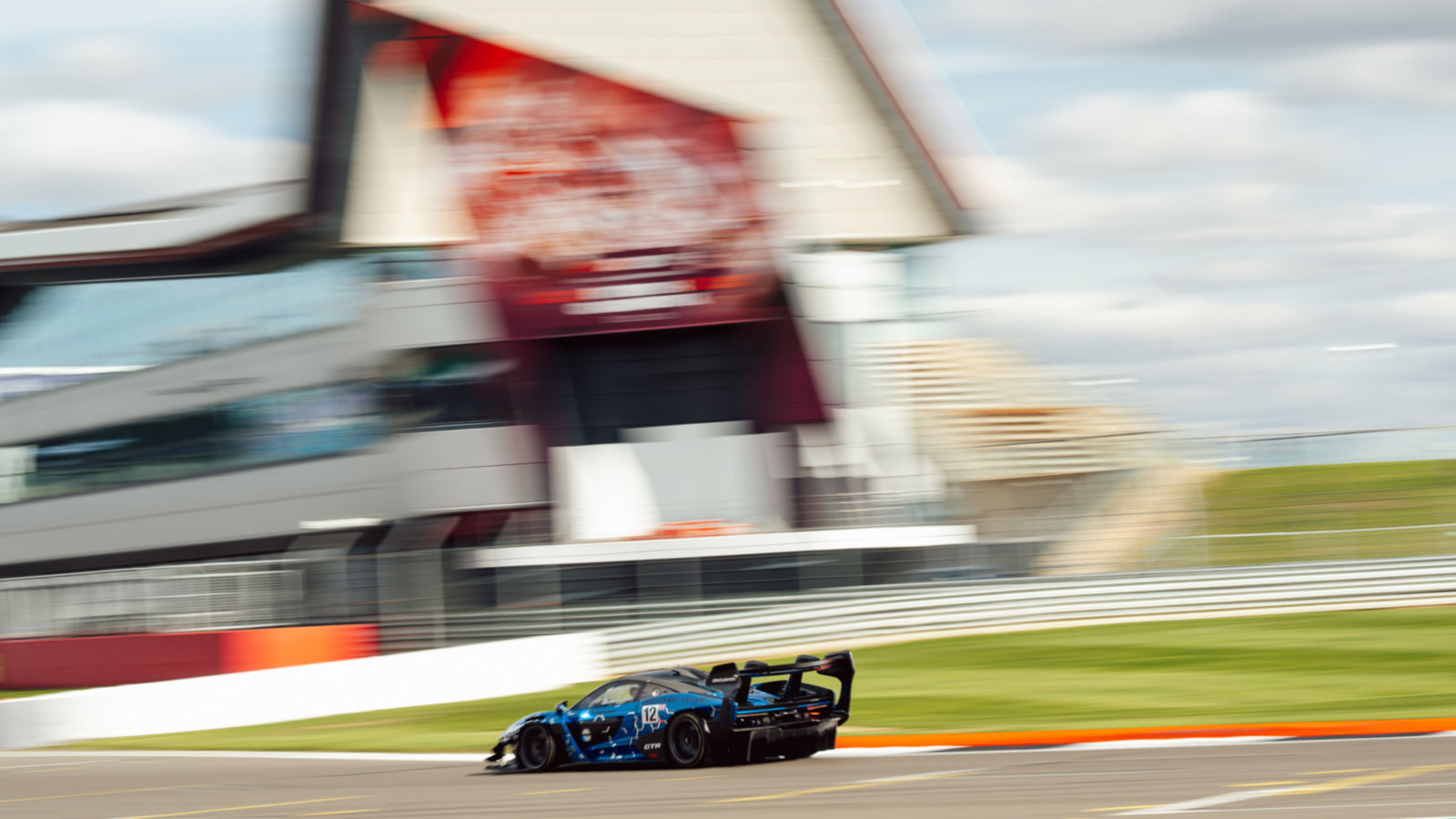 McLaren team and guests standing on trackside.