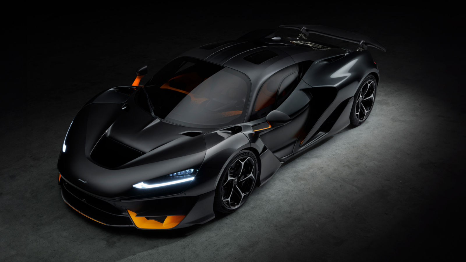 Black McLaren W1 in the shadows with a soft spot light exposing the front and side detail of the hypercar